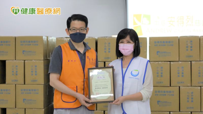 安得烈慈善協會執行長羅紹和(左)致贈感謝狀予台灣第一三共董事總經理林雪芬(右)帶領員工捐贈物資並參與食物箱包裝
