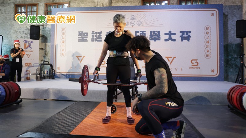 罹患腦幹癌的唐玉珍，在兒子（右）陪伴訓練下，舉起77.5公斤。